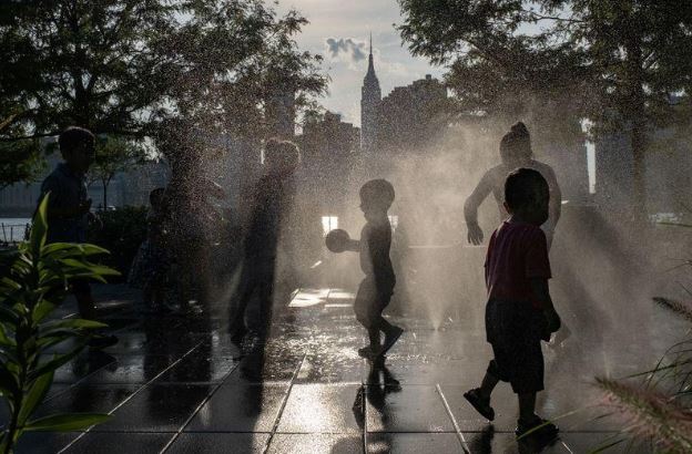 أطفال بالقرب من نافورة في نيويورك يوم 25 يوليو 2020. تصوير: جينا مون - رويترز